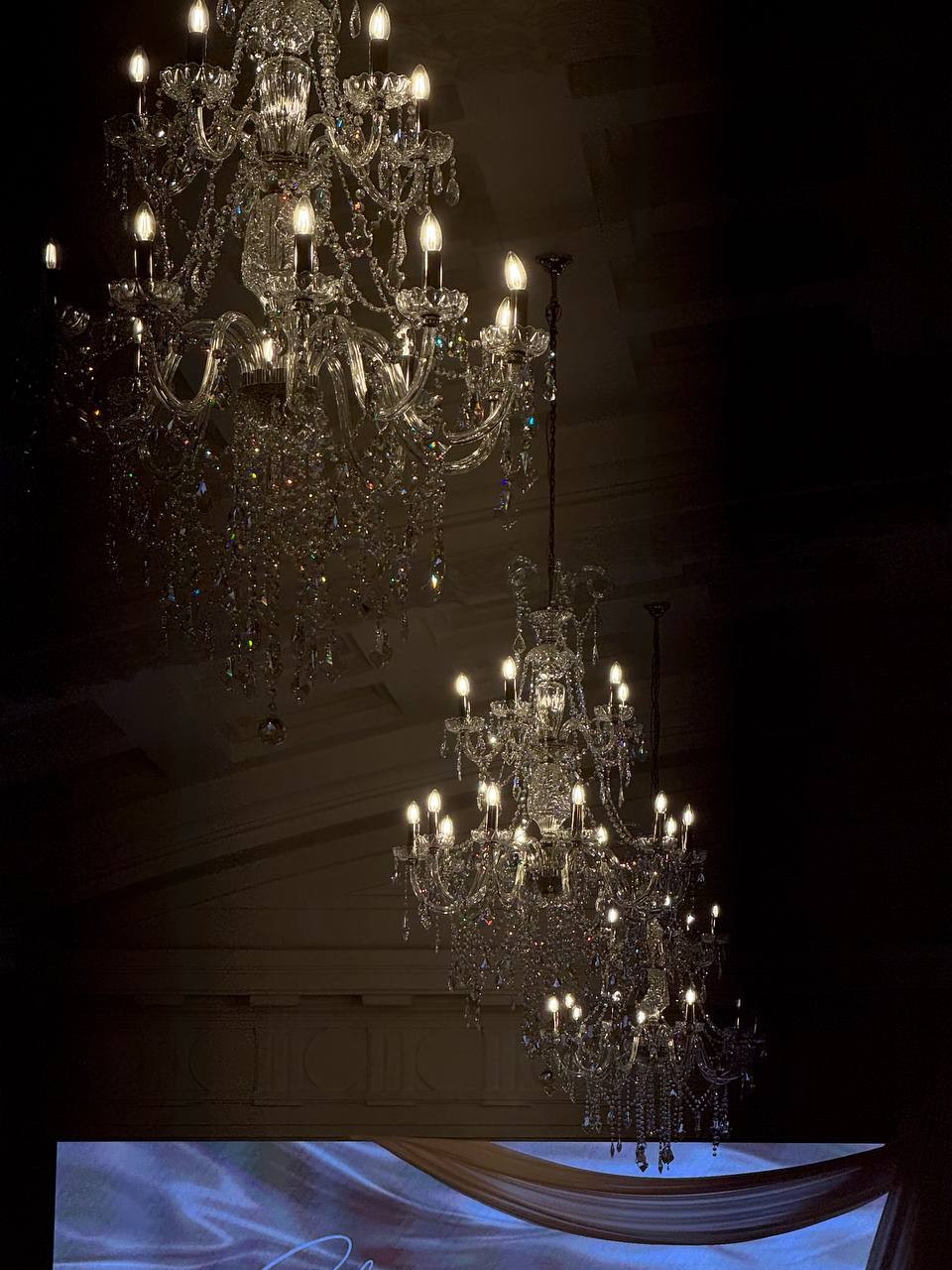 Chandeliers glowing above the wedding setting after dark
