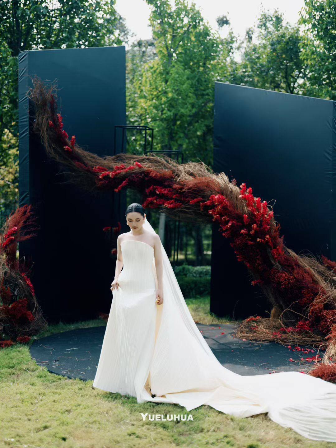 The bride beside a sculptural crimson floral installation
