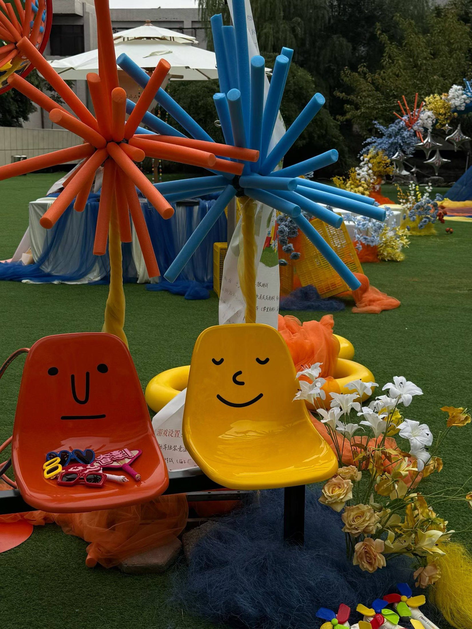 Colourful chairs, starburst forms and flowers on the lawn
