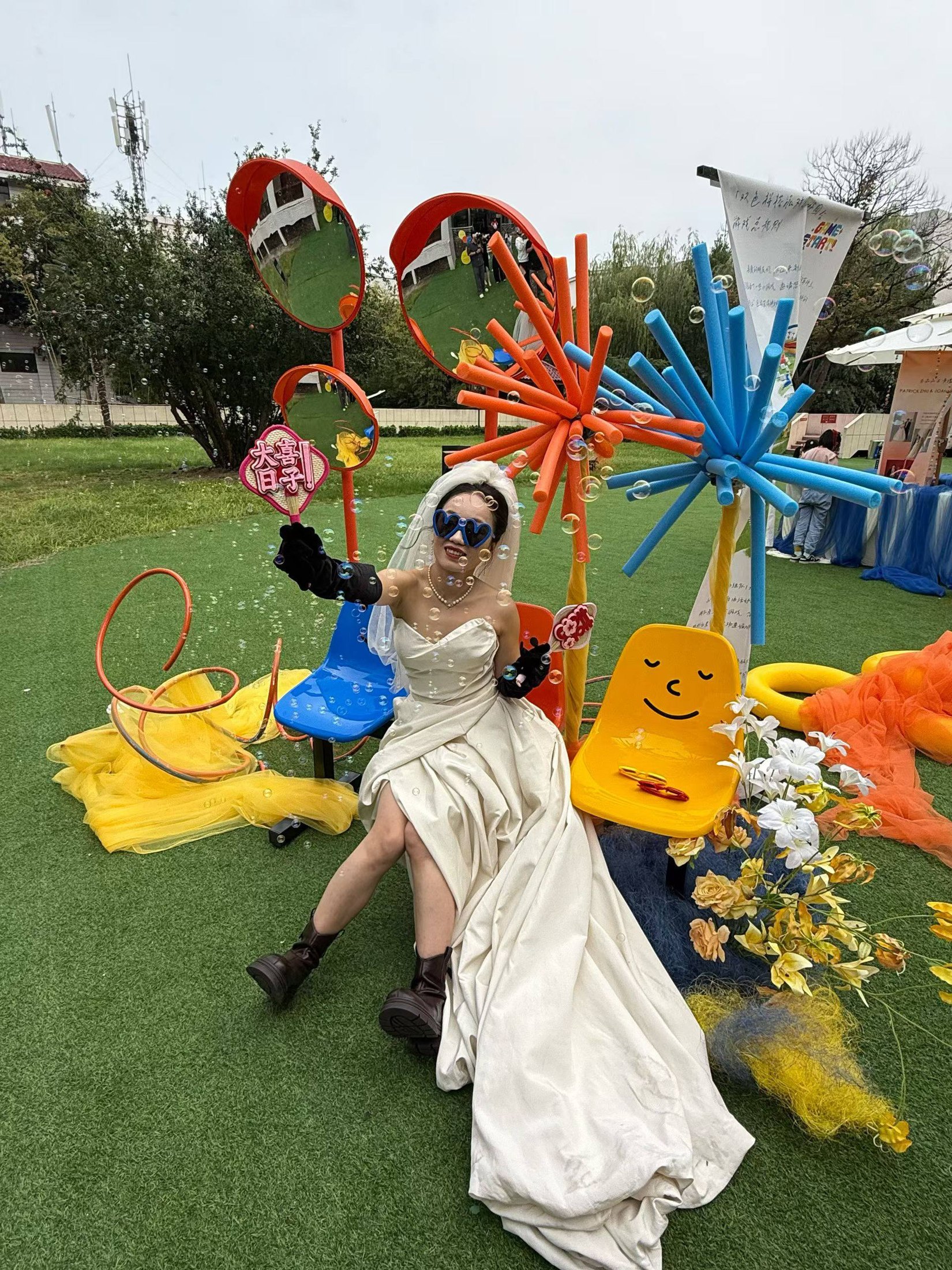 The couple seated among bright playful garden installations