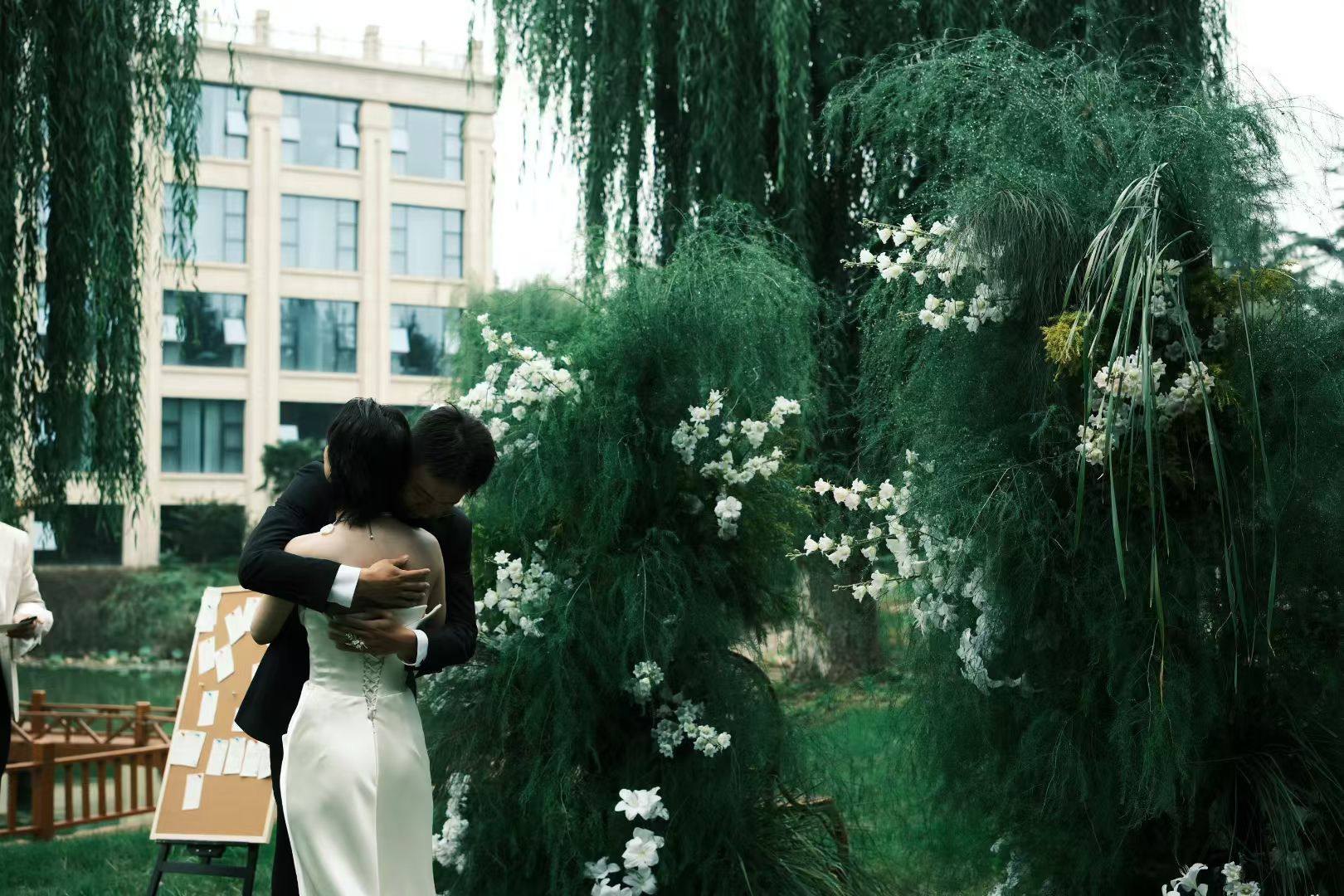 An embrace beside the garden ceremony flowers