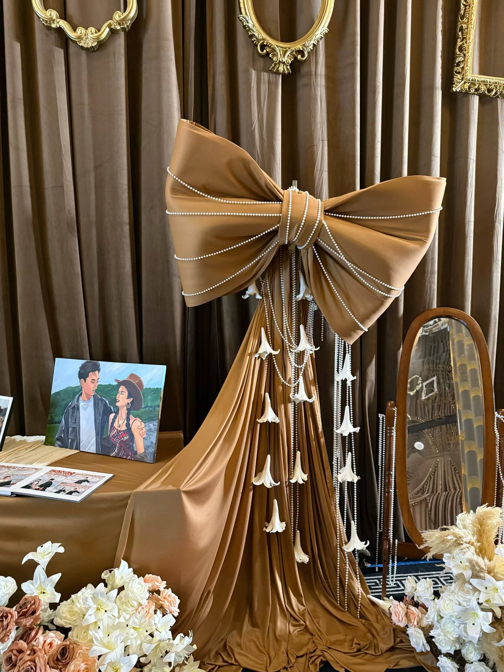 A large fabric bow and hanging details at the welcome table