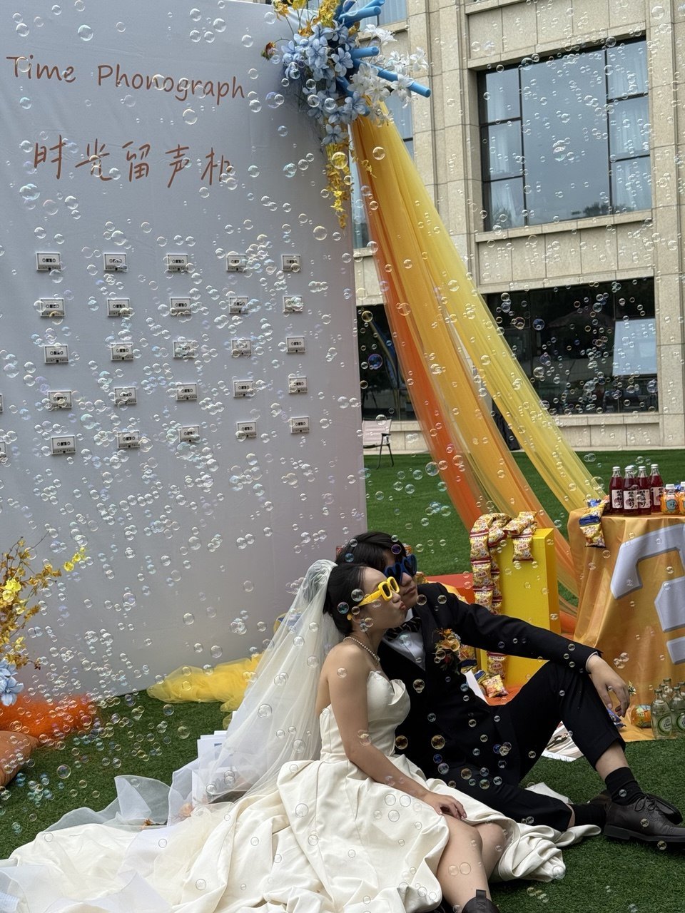 The couple beside a ribboned white welcome display