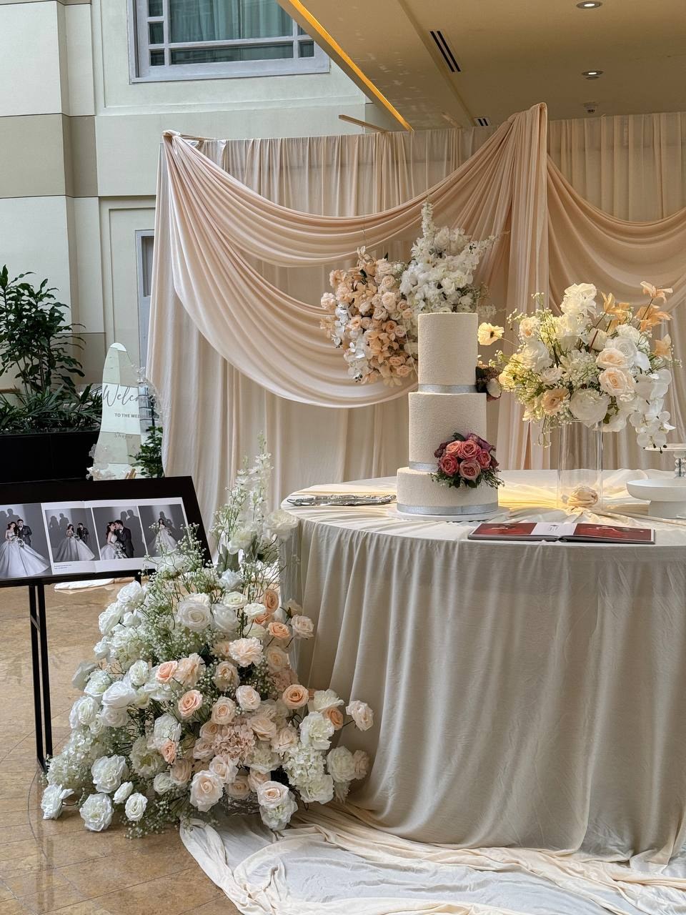 Draped welcome table with white flowers and personal photographs